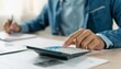 © Rahmat  - Close up hand of stress young asian businessman,male is pressing a calculator to calculate tax income and expenses, bills, credit card for payment or payday at home, office.Financial, finance concept.