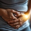 © Pniuntg - Person with intermittent abdominal pain, closeup of hand gripping the stomach, fluctuating discomfort