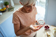 © Marko Geber - Elderly woman taking vitamins or medication at home