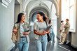 © HBS - Young modern female college students walking down corridor and talking. Relaxed and sincere atmosphere during the break.