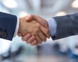 © sorrakrit - Two businessmen shaking hands in a professional setting, symbolizing agreement, partnership, and success.