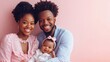 © A Denny Syahputra - A smiling couple holds their baby, enjoying a sweet family moment with a soft pink backdrop