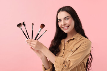 Poster - Beautiful makeup. Smiling woman with brushes on pink background