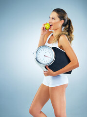 Sticker - Happy woman, apple and scale with diet for weight loss, fitness or exercise in studio on a blue background. Young female person or model with slim body or natural organic green fruit for nutrition