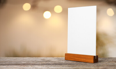 Wall Mural - Menu holder with blank card on wooden table in cafe. Mockup for design