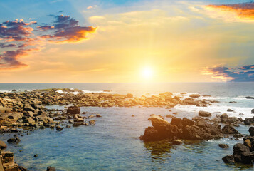 Wall Mural - Seascape with beautiful waves, rocky shore and bright sunrise .