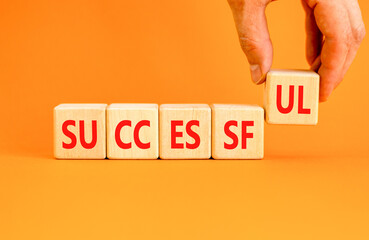 Successful symbol. Concept word Successful on beautiful wooden blocks. Beautiful orange background. Businessman hand. Business successful concept. Copy space.