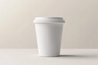 © Guy - A white coffee cup with a lid mockup sits on a table