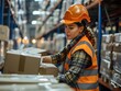 © pavlofox - Worker in an orange safety vest organizes boxes in a warehouse during the day