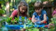 © Nadin Faust - two children, a girl and a boy, planting flowers in the garden using plastic bottles as pots on a sunny day, capturing teamwork and creativity with natural light and vibrant greenery