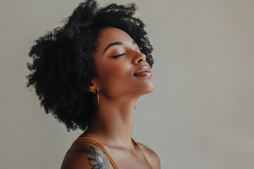 A close up of a tattooed black woman's face with her eyes closed