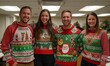 © Olga - Office staff are having fun at a party in ugly Christmas sweaters. Young office staff of different nationalities  in ugly  sweaters smile and look at the camera.