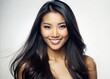 © Sirinporn - A stunning Asian female model with long, dark hair and flawless skin flashes a bright, warm smile against a crisp, white isolated background.