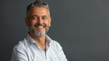 Attractive mature manager in casual attire, smiling happily in a contemporary studio portrait