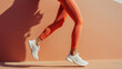 © Andreas - Dynamic shot of a woman running in orange leggings and white sneakers