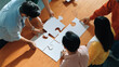 © Summit Art Creations - Top view of skilled business people gathering jigsaw piece together.Startup team with casual cloth standing at table while put jigsaw on table. Show unity, cooperation and team working. Convocation.