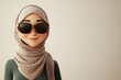 © ZEUS - Smiling cartoon woman in a patterned headscarf and sunglasses looking at the camera.