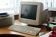 © pressmaster - Vintage computer setup including CRT monitor, keyboard, and printer on wooden desk, creating nostalgic work environment