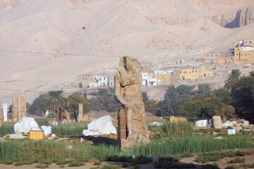 Famous Colossi of Memnon. Massive ruined statues colossi of the Pharaoh Amenhotep III. Travel and tourist landmarks nearby Luxor Egypt West Bank, Thebes, Luxor