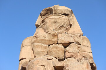 Famous Colossi of Memnon. Massive ruined statues colossi of the Pharaoh Amenhotep III. Travel and tourist landmarks nearby Luxor Egypt West Bank, Thebes, Luxor