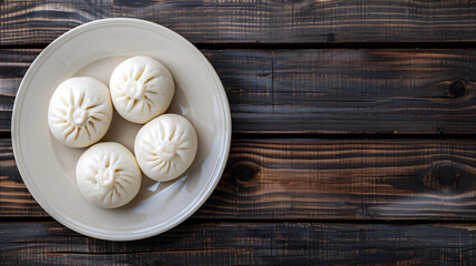 Canvas Print - Four steamed bao buns resting on a plate, served on a dark wooden table, providing a simple and elegant culinary backdrop