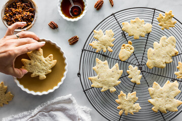 Wall Mural - A hand dipping a pecan shortbread cookie into a maple flavoured glaze.