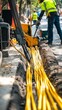 © keks20034 - Workers in uniforms and helmets lay fiber optic cables for internet in the city.