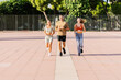 © Xavier Lorenzo - Front view of three young athletic friends jogging together outdoors in summer. Healthy lifestyle and sport concept
