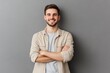© 为轩 张 - Portrait of a smiling young man in a beige shirt, standing with arms crossed, looking casually at the camera against a gray background.