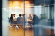 © 为轩 张 - Business team collaborating around a table in a modern office, captured through glass walls, planning for success with a blurred effect that adds dynamic movement, emphasizing teamwork and strategy.