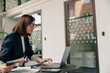 © Viktoria Kovalchuk - A businesswoman is focused and productive, working on her laptop in a modern office
