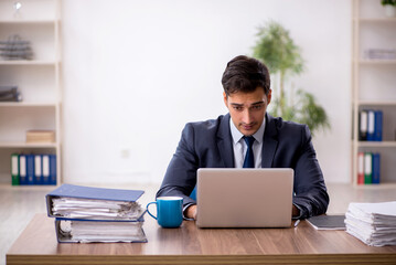 Wall Mural - Young male employee working in the office