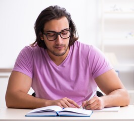 Poster - Young male student preparing for exams at classroom