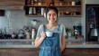 © ifoto - A happy young woman in overalls stands near the kitchen counter, holding coffee and wearing headphones