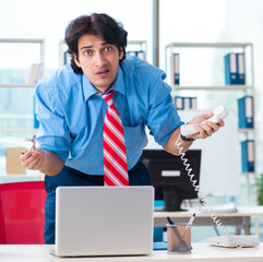 Wall Mural - Handsome businessman unhappy with excessive work in the office