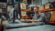 © pithak - technician using his computer at a desk in a warehouse