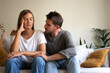 © Daniel - Man consoling sad wife sitting on the sofa at home living room. Copy space.