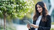 © SHI - Smiling young middle eastern Israel businesswoman using tablet pc application for online remote work at office business building outdoors.  Indian or arabic woman holding digital computer.