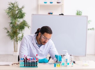 Wall Mural - Young male chemist working in the lab