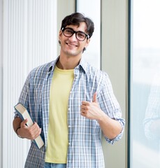 Wall Mural - Young handsome student standing at the window