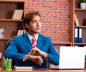 Wall Mural - Young handsome employee sitting in the office