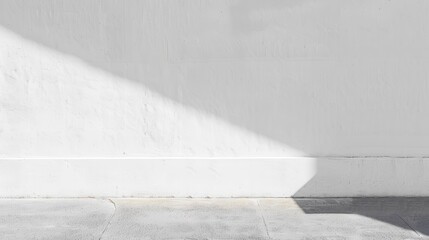 Poster - A white wall with a single shadow cast by sunlight in the afternoon. The shadow is sharp and well-defined, extending from the top of the wall down to the concrete floor below.