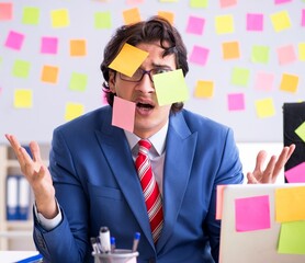 Wall Mural - Young male handsome employee in conflicting priorities concept