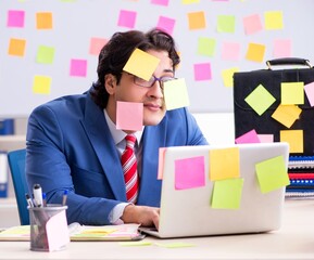 Wall Mural - Young male handsome employee in conflicting priorities concept