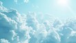 © vadosloginov - The image shows a bright blue sky filled with fluffy white clouds. The sun is shining brightly, casting a soft glow on the clouds. The clouds are clustered together, creating a beautiful and peaceful