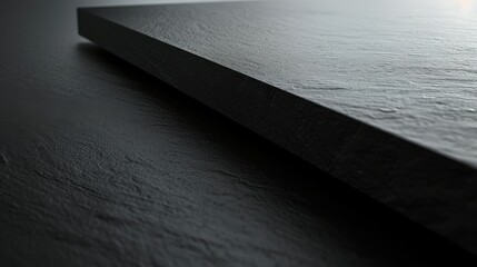 Leinwandbilder - A close-up image of two flat black slate surfaces in a studio. One surface is slightly raised and positioned diagonally over the other, creating a textured, minimalist background. The natural texture 