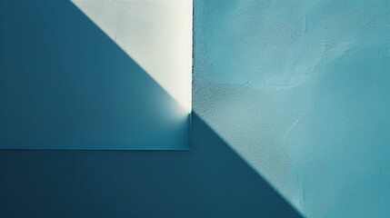 Leinwandbilder - The photograph captures a corner of a wall painted in a calming shade of blue. A beam of sunlight enters the room, casting a triangular shadow across the wall and illuminating the corner.