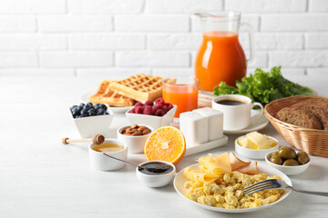 Sticker - Tasty breakfast. Scrambled eggs, ham, cheese and other food served on light table