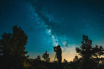 Wall Mural - photographer capturing long-exposure shots of the milky way.