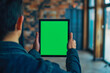 © VisualProduction - Rearview shot of an unrecognizable young man using his tablet with green screen
